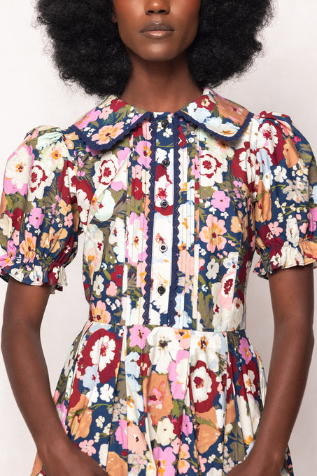 Multicolored floral dress worn by a model on a white background