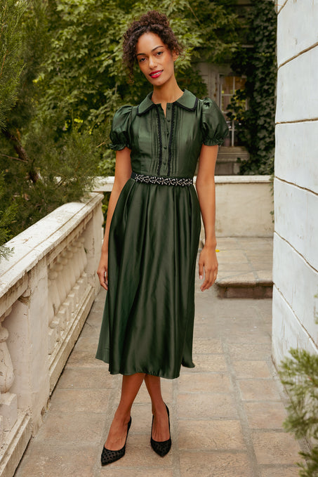 Woman wearing a green dress with a belt in an outdoor setting