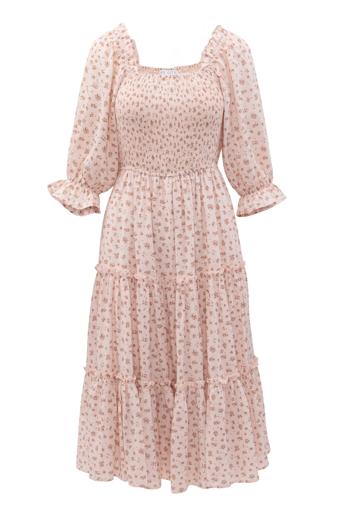 The Madeline Dress In Pink by Ivy City Co is a floral, tea-length midi with a smocked bodice, ruffled cuffs, and tiered skirt. Its stretchy fit and delicate print make it elegant and maternity friendly.
