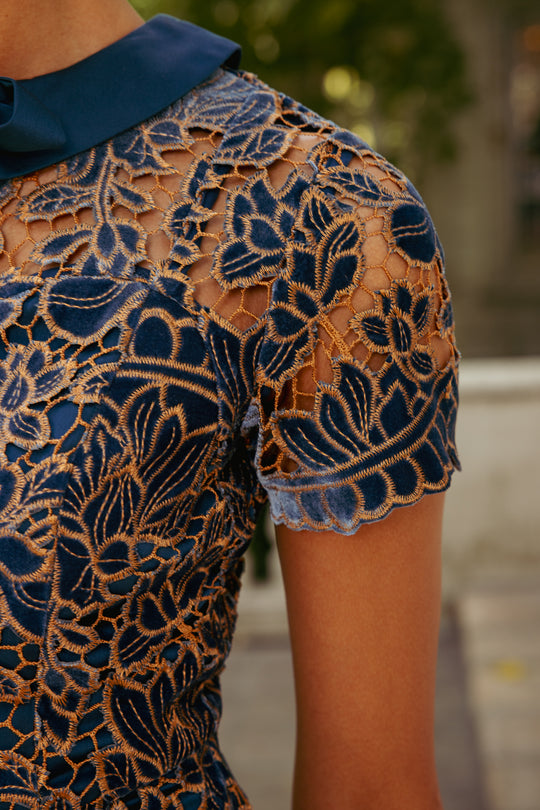 Close-up of a person wearing a patterned top with a blurred background
