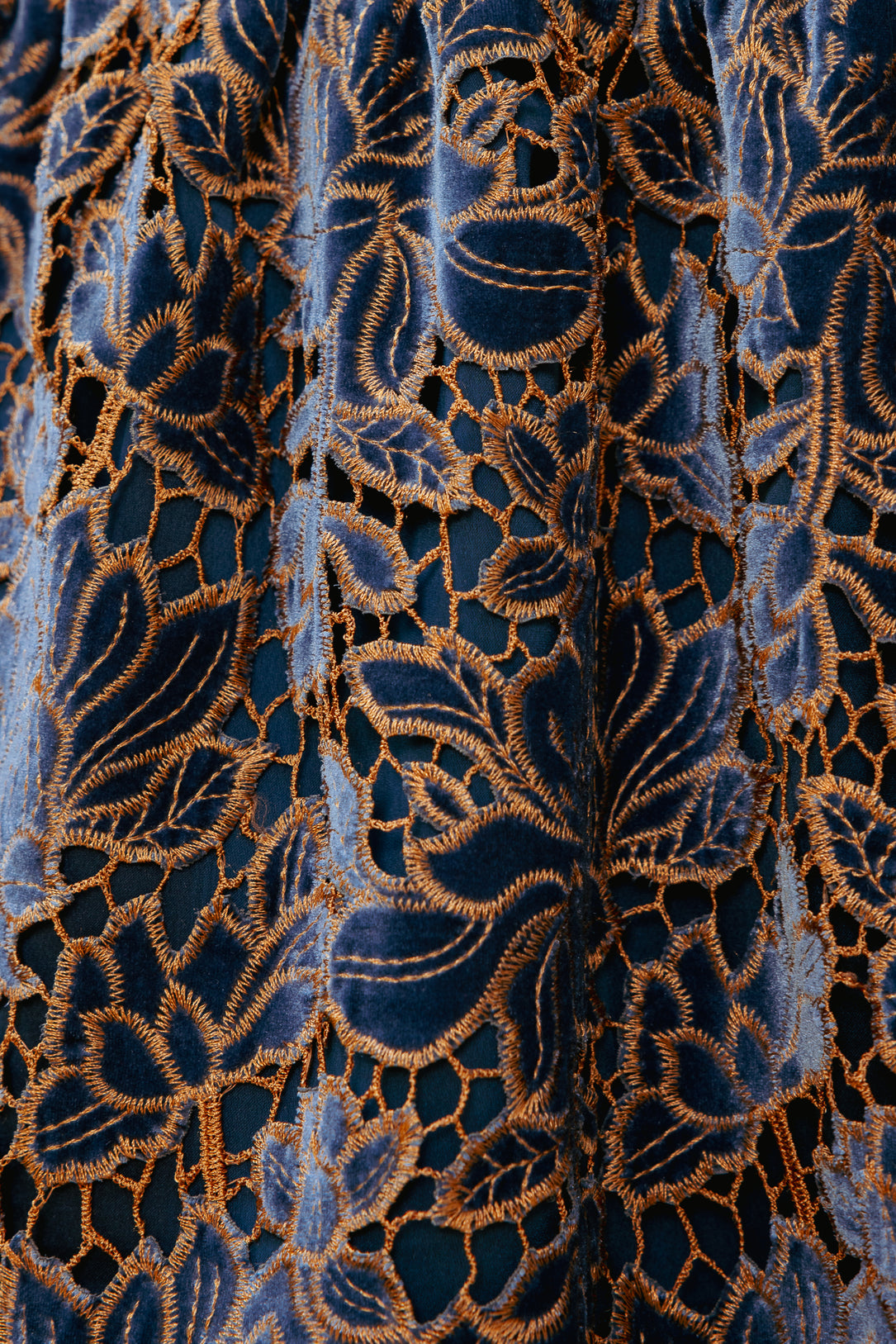 Close-up of a blue fabric with intricate gold embroidery