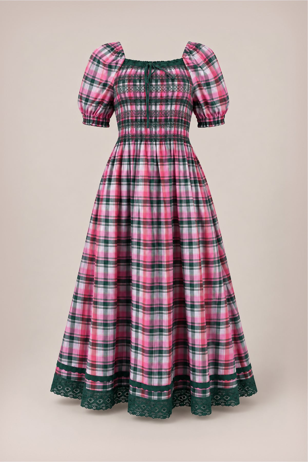 The Sunday Best Dress in Vibrant Plaid by Ivy City Co features pink, white, and green plaid with puffed short sleeves, a smocked bodice, and green lace trim at the hem—making it an ideal festive Christmas dress—displayed against a plain beige background.
