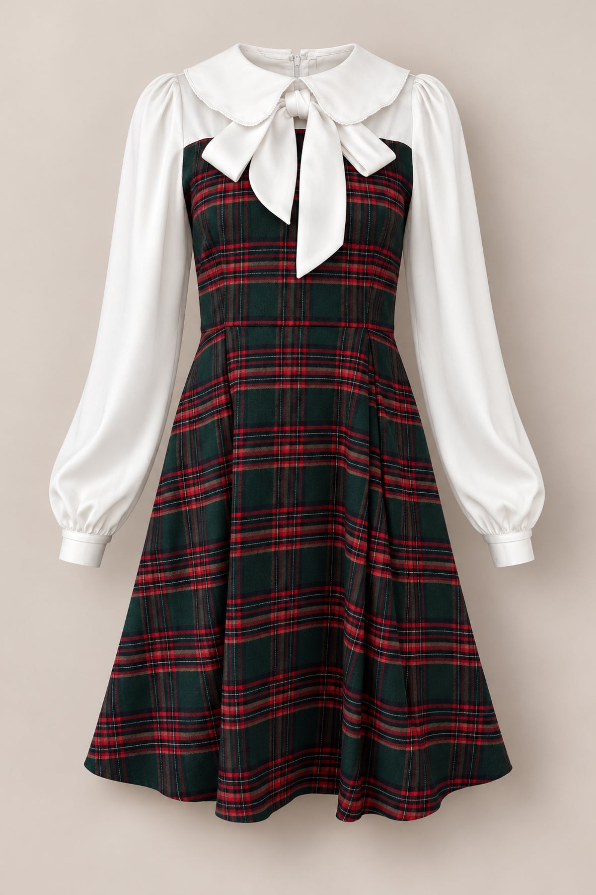 Introducing the Tawny Dress in Evergreen Plaid by Ivy City Co—a delightful girls’ holiday dress showcasing a timeless, vintage-inspired design. This charming dress features a green and red plaid patterned bodice and skirt, crisp white long sleeves, and a standout large white collar adorned with a bow. Perfect for festive celebrations!.