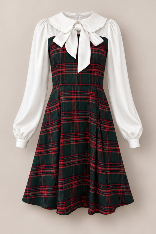 Introducing the Tawny Dress in Evergreen Plaid by Ivy City Co—a delightful girls’ holiday dress showcasing a timeless, vintage-inspired design. This charming dress features a green and red plaid patterned bodice and skirt, crisp white long sleeves, and a standout large white collar adorned with a bow. Perfect for festive celebrations!.