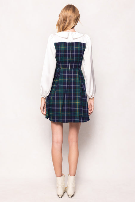 Person wearing a plaid dress over a white shirt on a white background