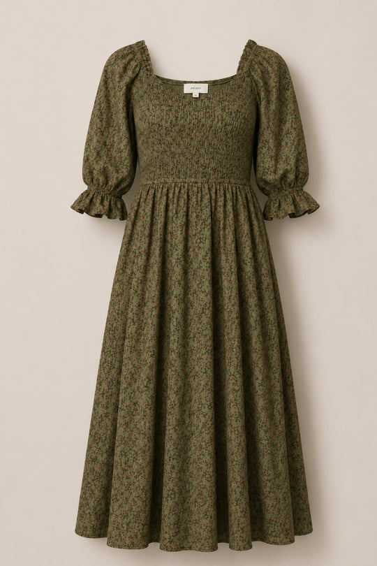 The Ivy City Co Teagan Dress in Woodland Floral is an olive green midi dress featuring a delicate woodland floral pattern, short puffed sleeves with ruffled cuffs, a smocked bodice, and a square neckline. Displayed against a light beige background, this maternity-friendly dress combines effortless style with comfort—making it the perfect choice for any occasion.