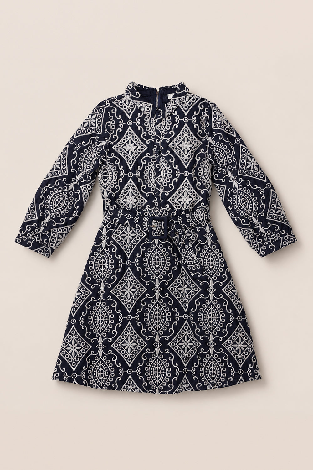 A long-sleeve, midi-length dress in the Teen Clover Dress in Midnight Tile by Ivy City Co, showcasing a black and white geometric and paisley print, with a high neckline and a coordinating fabric belt at the waist, is laid flat on a light background. This classic design reflects the elegant silhouette characteristic of the Ivy City Co x Miriam collection.