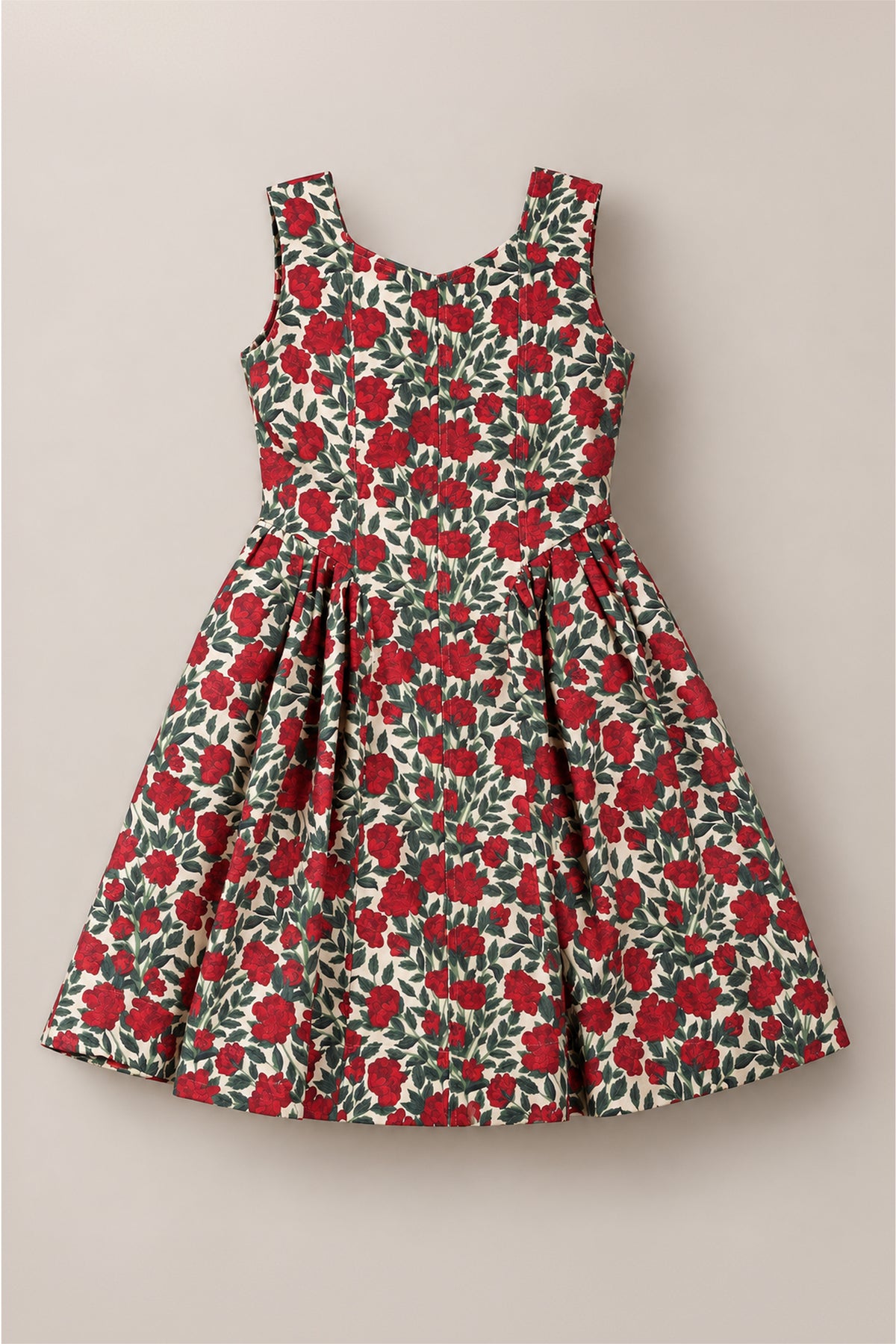 The Teen Edith Dress in Red Roses by Ivy City Co features a sleeveless design with a fitted bodice and pleated skirt. Showcasing a bold red rose floral pattern with green leaves on an off-white background, this dress stands out as the perfect choice for holiday parties.