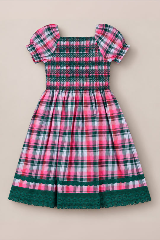 The Ivy City Co Teen Sunday Best Dress in Vibrant Plaid features a charming pink, green, and white plaid pattern, a smocked bodice, puff sleeves, and delicate green lace trim at the sleeves and hem—making it the perfect festive Christmas dress or a delightful smocked cotton dress for any special occasion.