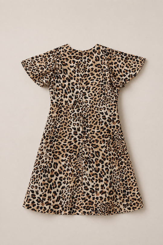 The Ivy City Co Teen Tallulah Dress in Leopard is a short-sleeve, knee-length dress featuring a flared skirt and chic brown, black, and beige leopard print, displayed flat on a neutral background—an effortlessly stylish midi choice perfect for teens.