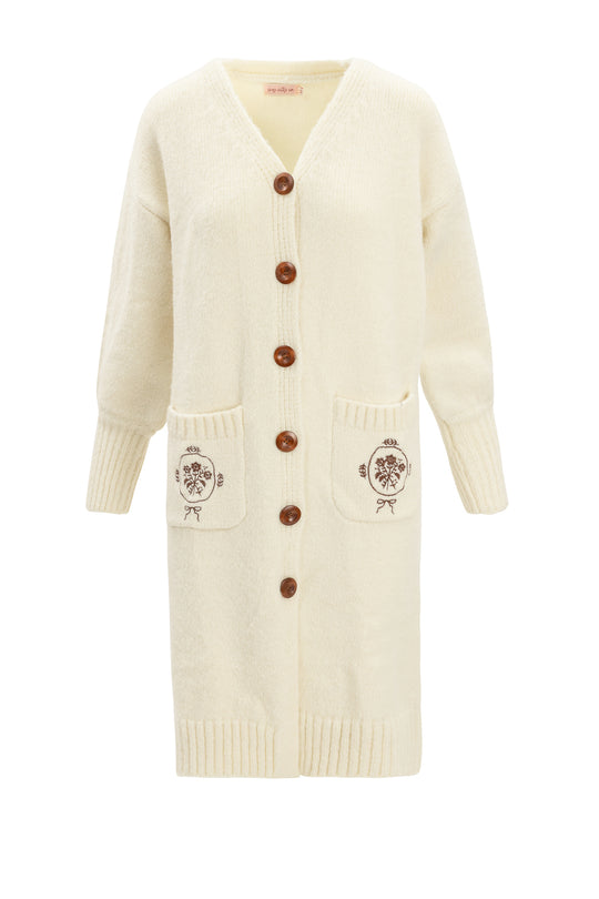 The Teresa Cardigan in Cream by Ivy City Co features large brown buttons, ribbed cuffs and hem, two floral-embroidered pockets, a cozy relaxed fit, V-neckline, and a maternity nursing-friendly design.