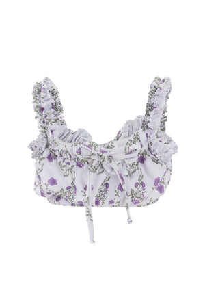 The Mini Thea Top in Maeve Floral by Ivy City Co is a cropped, sleeveless white swim top with purple floral prints, ruffled shoulder straps, and a front tie—perfect for girls’ swimwear collections.