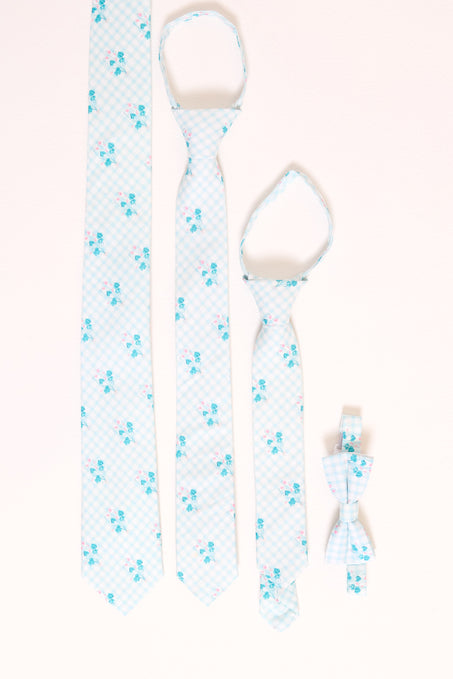 an assortment of blue floral ties laying flat against a white backdrop