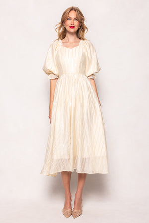 Woman wearing a white dress against a plain background