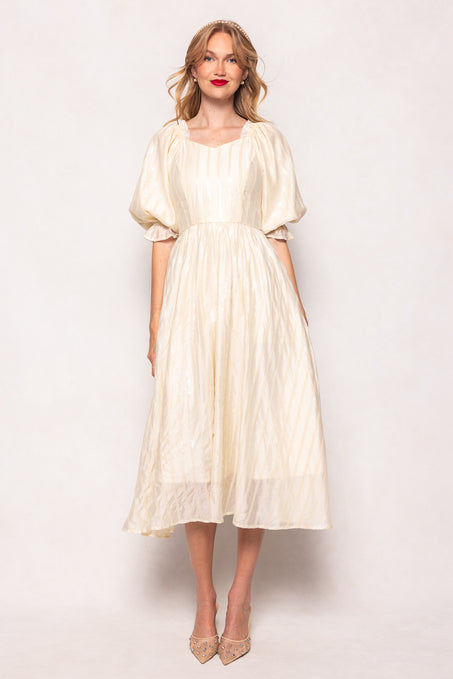 Woman wearing a white dress against a plain background