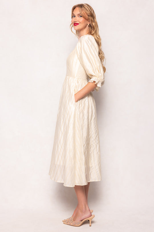 Woman wearing a white dress against a plain background