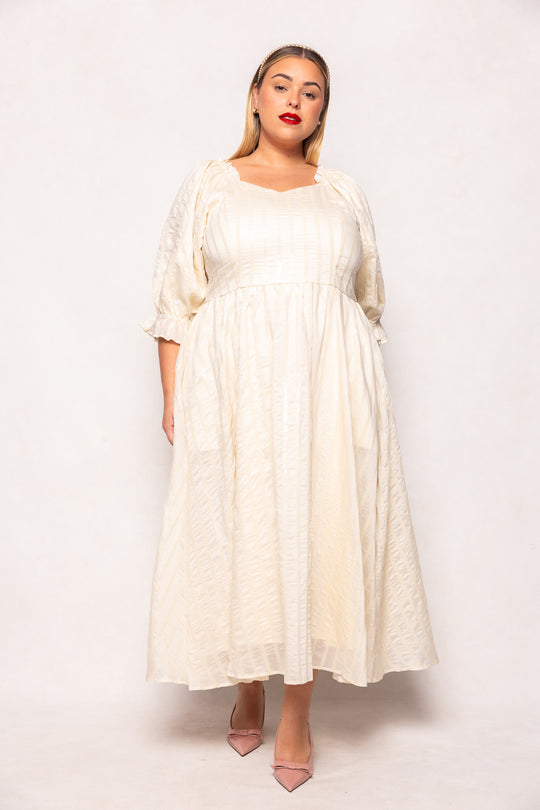 Woman wearing a white dress against a plain background