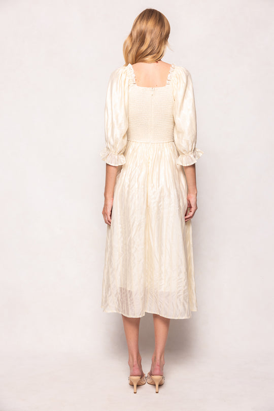Woman wearing a cream-colored dress against a white background