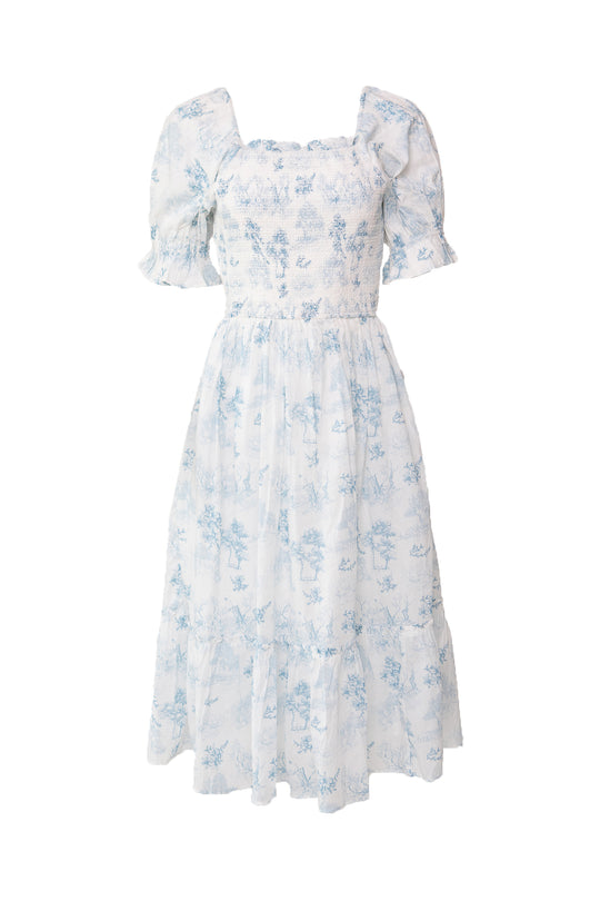 The Ivy City Co Valencia Dress is a light blue and white floral cotton dress with puffed short sleeves, smocked bodice, square neckline, and tiered skirt. Maternity friendly for comfortable, effortless style.
