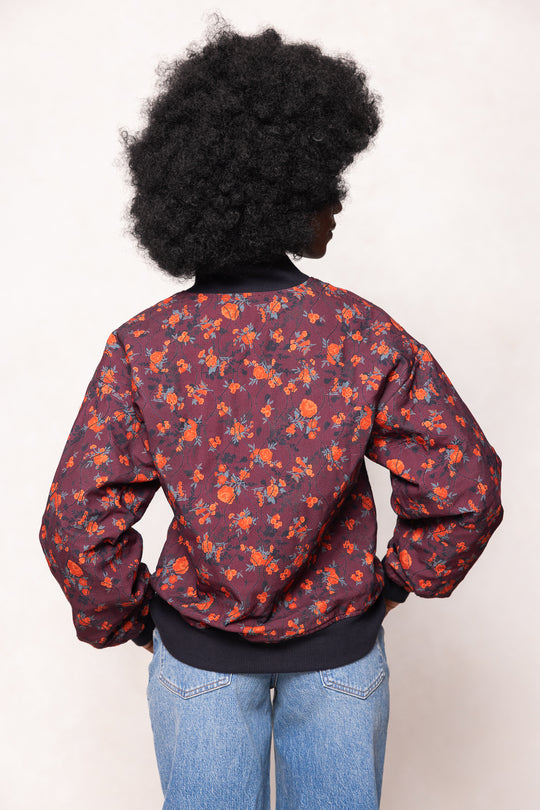 Person wearing a floral-patterned jacket with a plain background