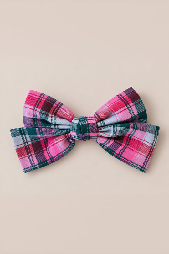 The Ivy City Co Hair Bows in Vibrant Plaid, featuring a large bow crafted from pink, green, and blue fabric, is displayed against a plain beige background, making it a charming holiday accessory.