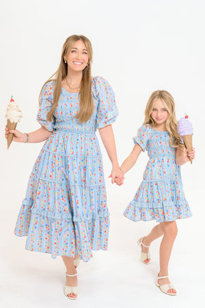 woman and young girl holding hands and holding ice cream cones against a white background