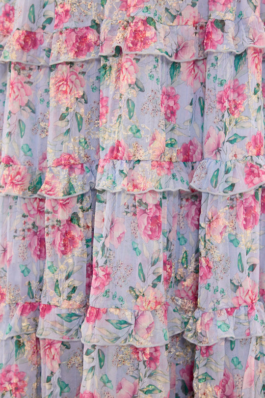 Floral tiered dress with ruffles on a light blue background