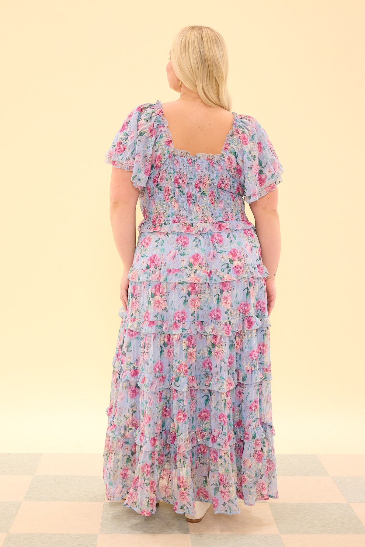 Woman wearing a floral dress on a beige background
