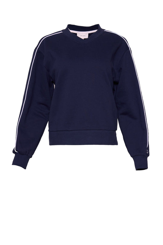 The Kinsley Sweatshirt in Navy by Ivy City Co features a classic crew neckline, long sleeves with white piping along the shoulders and sleeves, ribbed cuffs and waistband, all crafted from soft cotton fleece. Shown against a plain white background, this versatile pullover is perfect for effortless style.