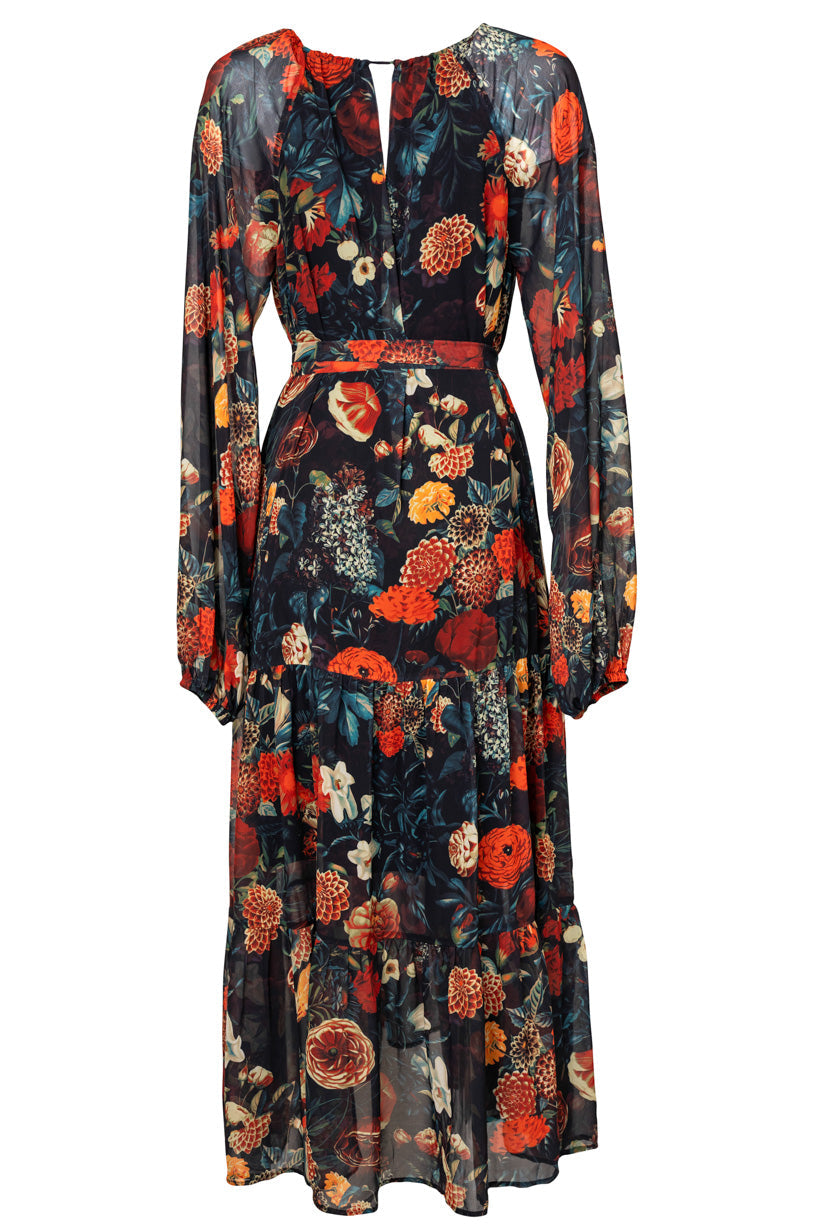 The Imogen Dress in Moody Floral by Ivy City Co is a long-sleeve, ankle-length maxi dress featuring a vibrant red, orange, yellow, and green floral print on dark semi-sheer fabric. With a fitted waist, round neckline, and delicate gathering at the skirt and cuffs, this elegant style is versatile and maternity friendly.