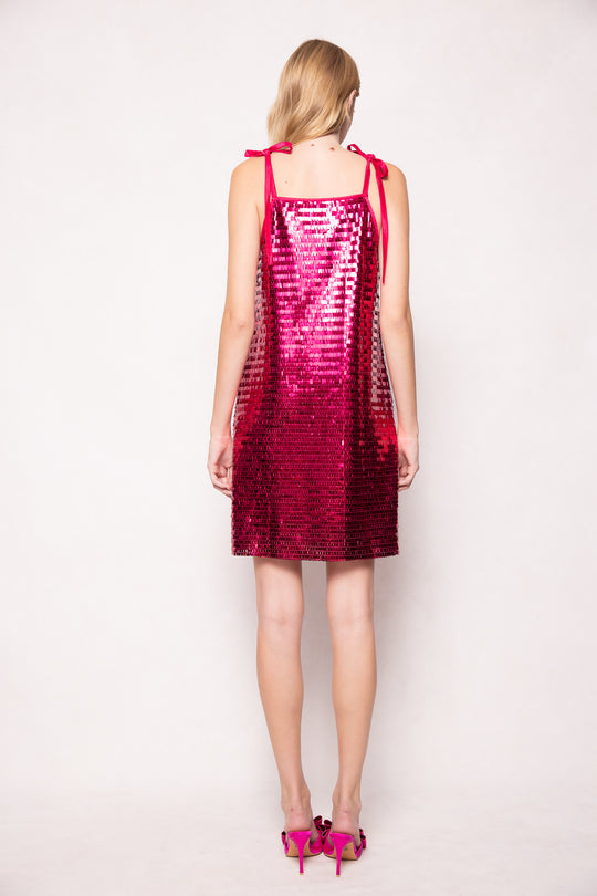 Woman wearing a red sequin dress against a white background