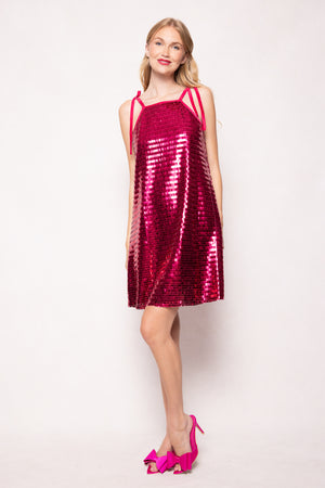 Woman wearing a red sequin dress with pink shoes on a white background