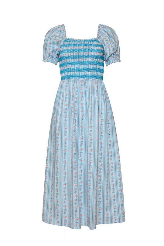 The Sunday Best Dress in Rosette Linear Stripe by Ivy City Co is a blue and white cotton midi dress featuring puffed short sleeves, a smocked bodice, and vertical floral stripe patterns. Designed with a square neckline and a loose, flowy fit from the waist down, this summer dress is beautifully maternity friendly as well.