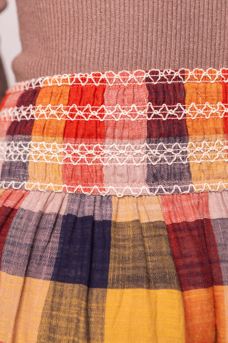 Close-up of a colorful fabric with a checkered pattern and smocked waistband.