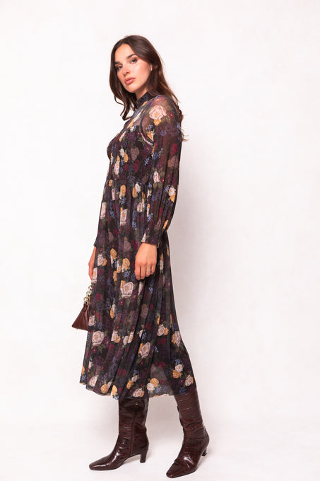 Woman wearing a floral dress and brown boots on a white background