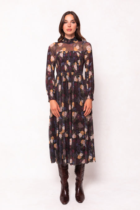 Woman wearing a patterned dress with long sleeves on a white background