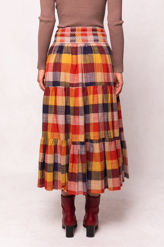 Person wearing a plaid skirt with a plain background