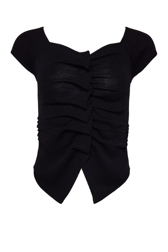 The Aspen Shirt in Black by Ivy City Co is a black short-sleeve stretchy knit top featuring a sweetheart neckline, ruched front detailing, a single front button, and an asymmetric hem with a front slit—thoughtfully designed to be nursing-friendly without sacrificing style.