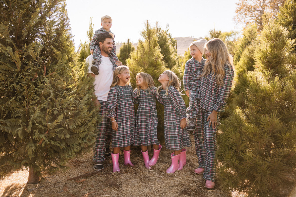 The Fisher family in matching plaid pajamas and pink rain boots at a Christmas tree farm