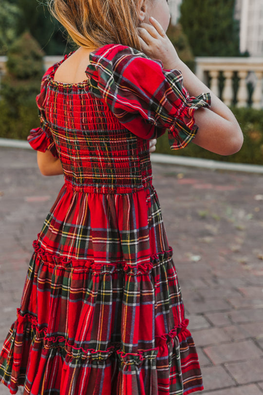 Red plaid dress worn by a person, with a blurred outdoor background