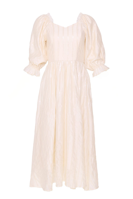 The Tindra Dress in Cream Sequin by Ivy City Co is a maternity-friendly, cream-colored midi dress featuring elegant puff sleeves with gathered cuffs, a fitted bodice, square neckline, and a flared skirt. The fabric boasts a subtle sheen and textured pattern. No visible accessories or background.