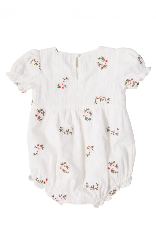 The Ivy City Co Baby Jessie Romper in Ditsy Embroidery features puffed short sleeves, a gathered waist, and delicate pink and green floral embroidery scattered throughout. Made from soft embroidered cotton, it is finished with a small buttoned keyhole opening at the back.
