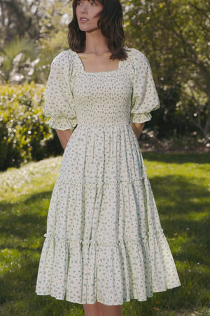 Woman wearing a floral dress standing in a garden