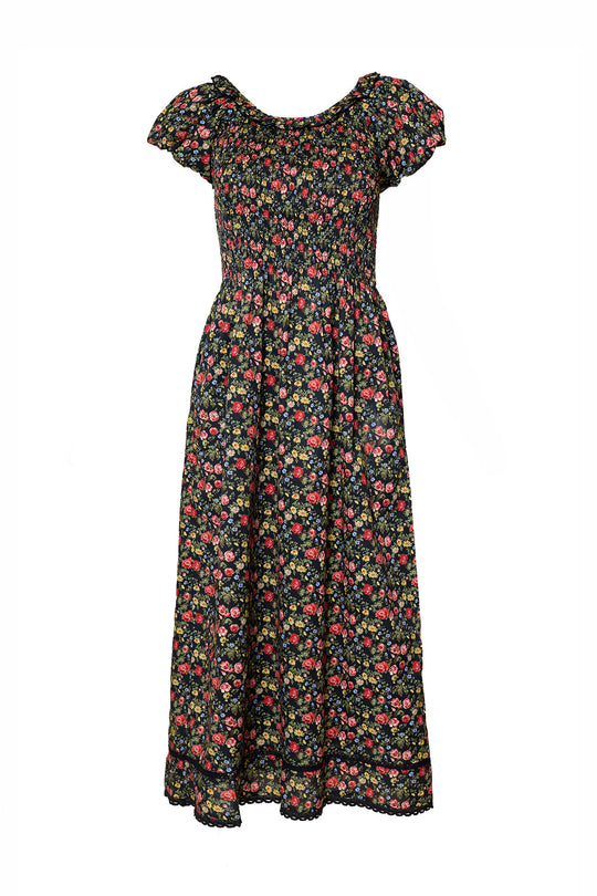 The Annalise Dress in Obsidian Vintage Poppies by Ivy City Co is a black, ankle-length dress adorned with a vibrant floral print of red, pink, and yellow flowers. It features short, ruffled sleeves and a smocked bodice for a comfortable, maternity-friendly fit.