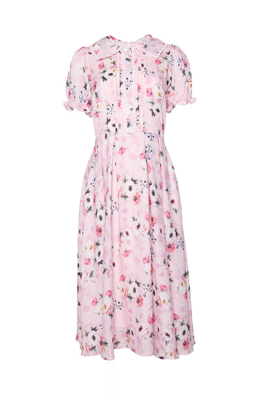 The Sophia Dress in Roselyn Pink by Ivy City Co is a light pink, short-sleeved, mid-length cotton-linen dress featuring a charming floral pattern, puffed sleeves, pleats on the bodice, and a flowy skirt.