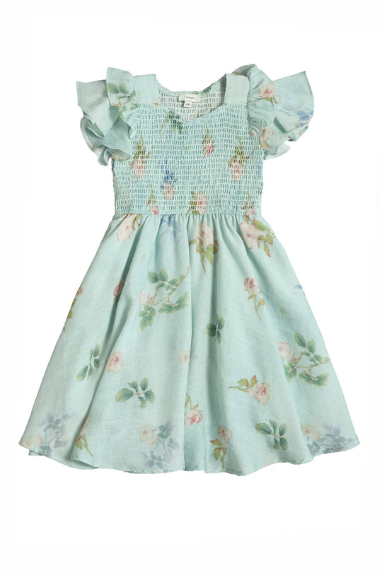 Sweet and stylish, the Mini Hattie Dress in Roselyn Blue by Ivy City Co is perfect as a girls’ party dress. Crafted from a soft cotton-linen blend, it features short ruffled sleeves, a smocked bodice, and a flared skirt adorned with a delicate pastel flower print.