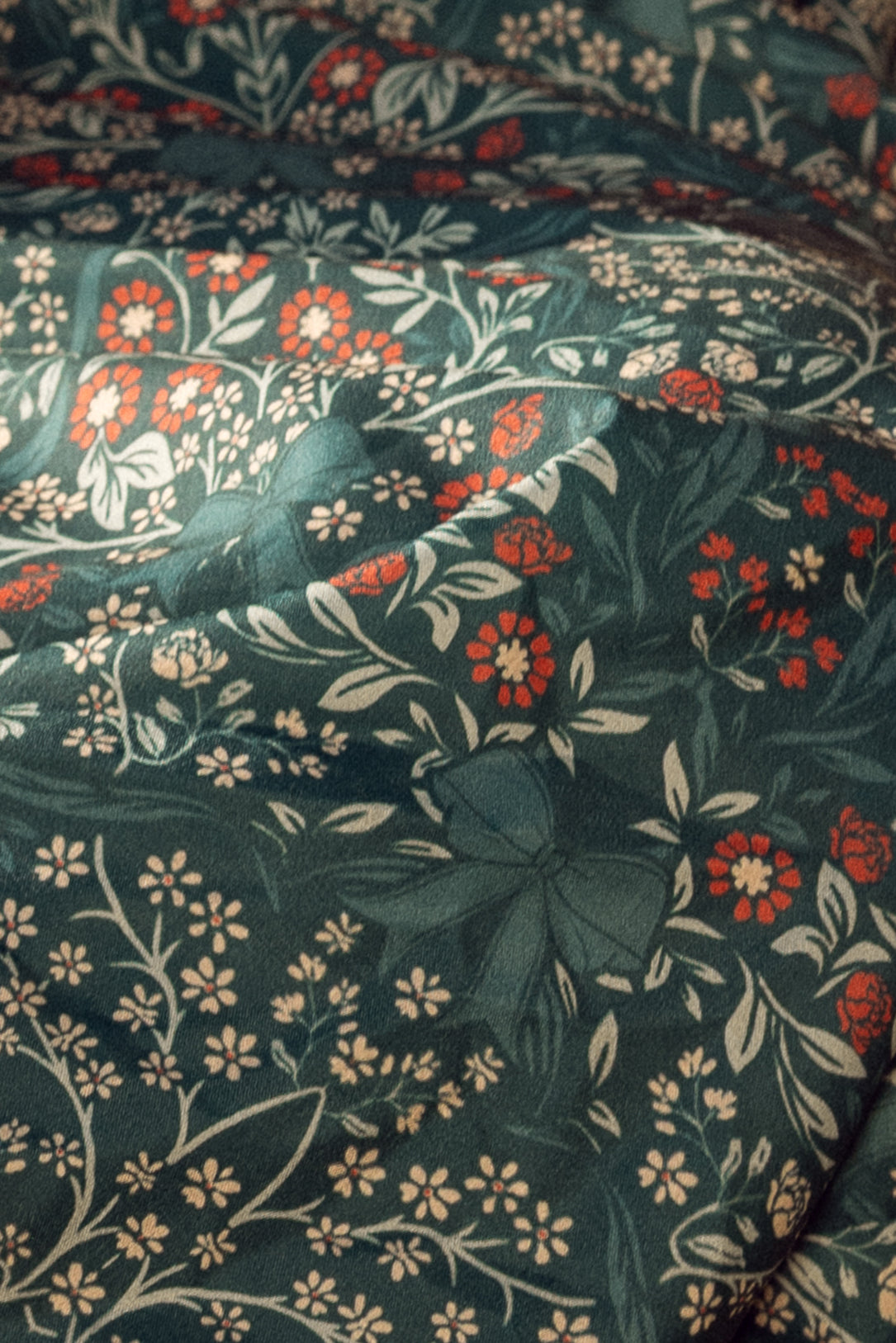 Close-up of floral fabric with red, white, flowers on a teal blue background