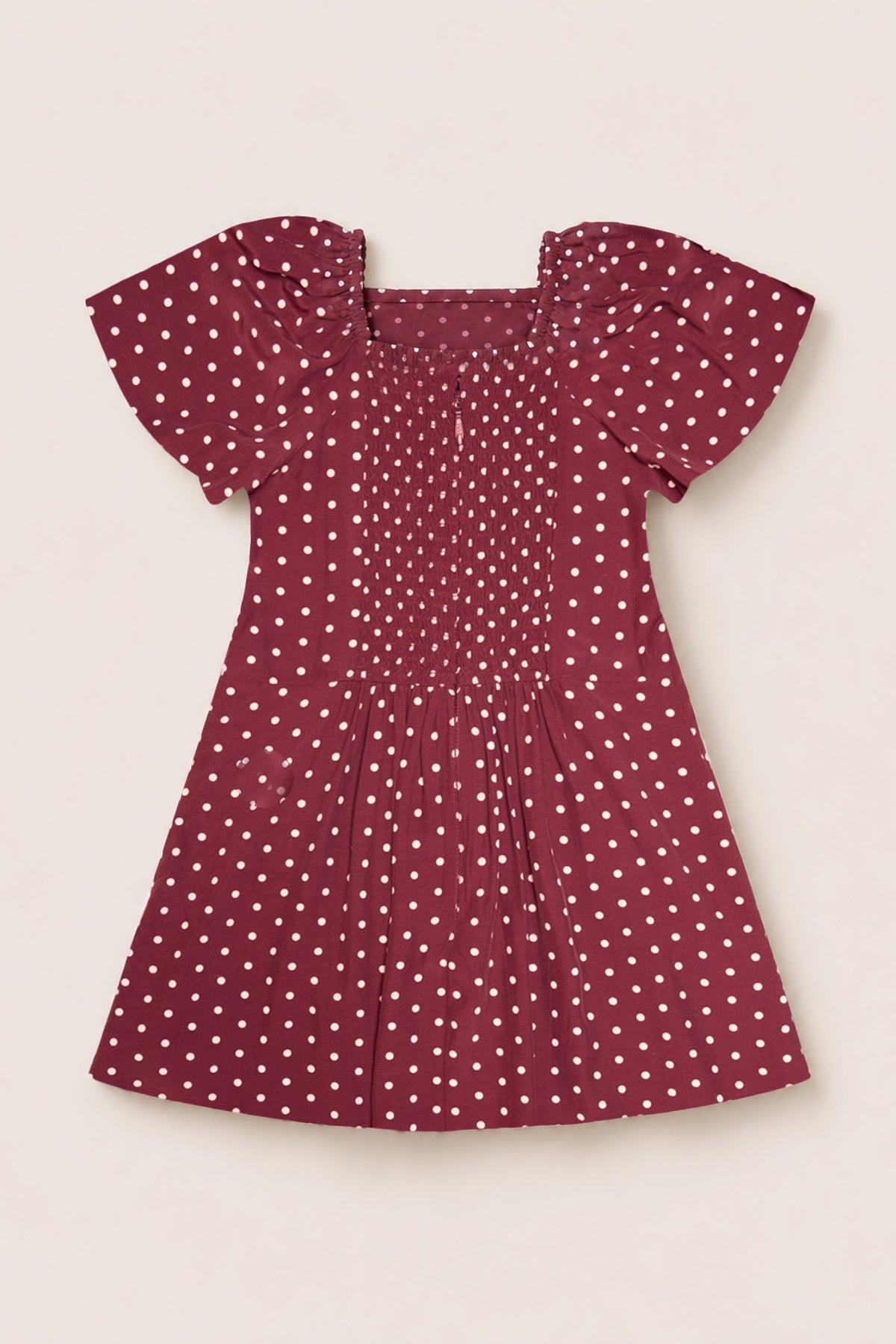 A short-sleeve Teen Blakely Dress in Cranberry Dainty Dot by Ivy City Co, featuring white polka dots, petal sleeves, and a smocked bodice. This midi-length dress is laid flat on a light background.