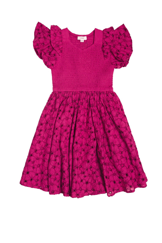 The Ivy City Co Mini Hattie Dress in Magenta is a bright pink cotton girls’ midi dress with ruffled short sleeves, a smocked bodice, and a flared skirt featuring a dotted floral pattern. Perfect as a Mini & Me Easter dress, it has a round neckline and is beautifully presented against a white background.