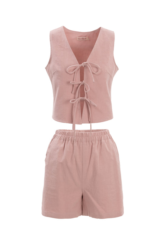 The Skye Shorts in Pink by Ivy City Co are linen-cotton shorts with an elastic waistband, shown with a light pink sleeveless crop top featuring a lace-up front, all displayed on a white background.